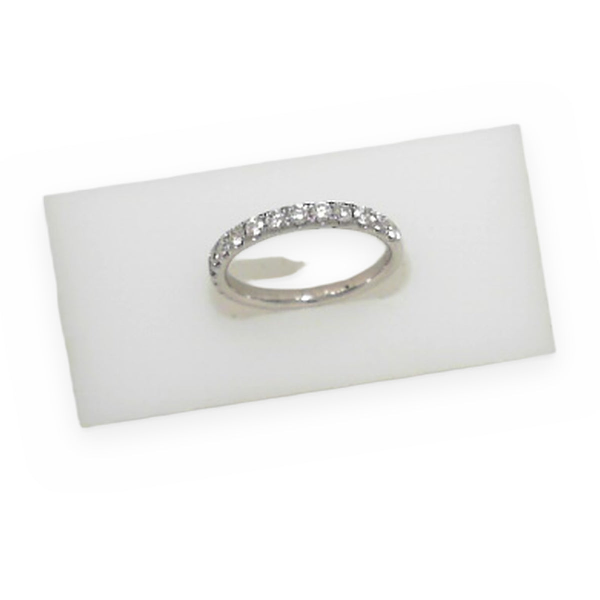 White gold diamond band resting in a frosted display block