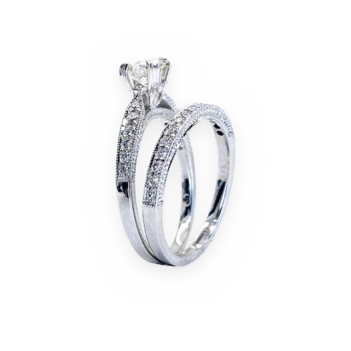 White gold round diamond engagement ring and diamond band shown standing upright