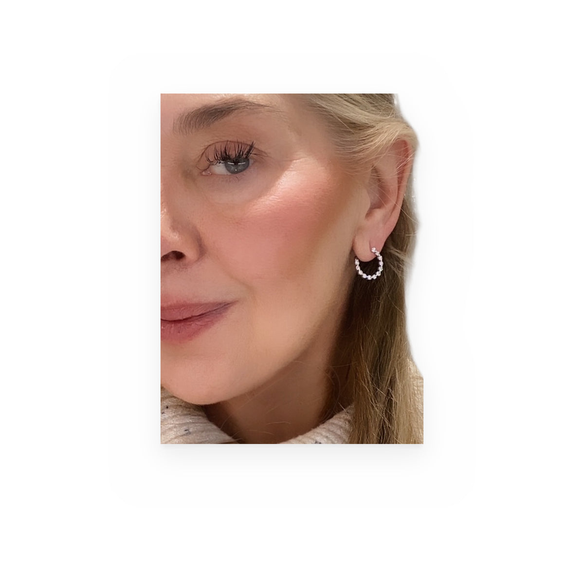 Woman wearing a white gold open-circle diamond hoop earring