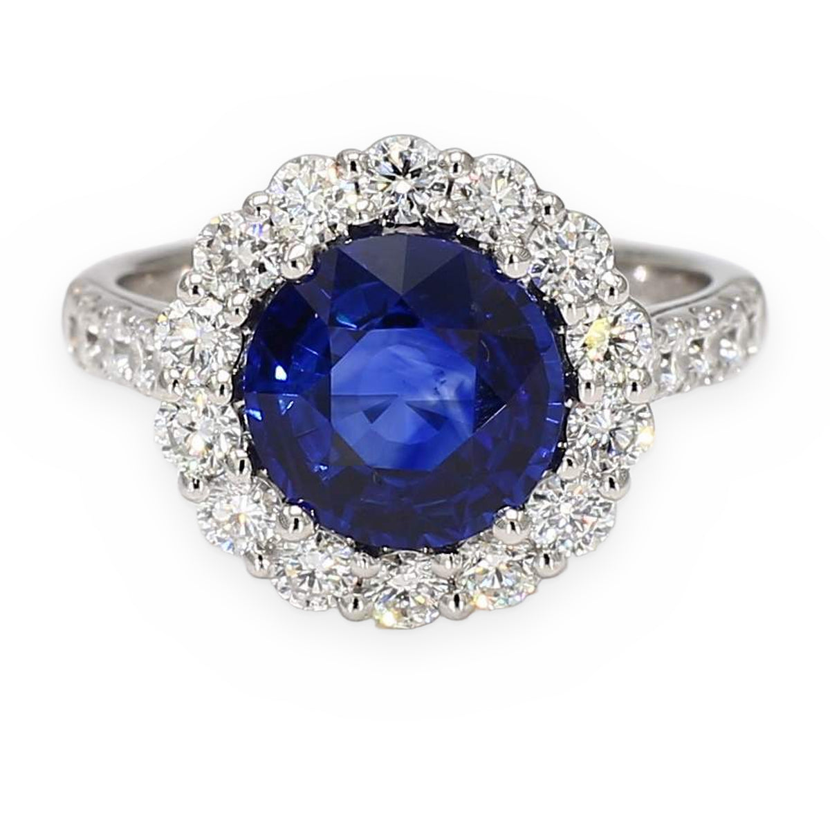 White gold ring with a round blue sapphire center and a full diamond halo