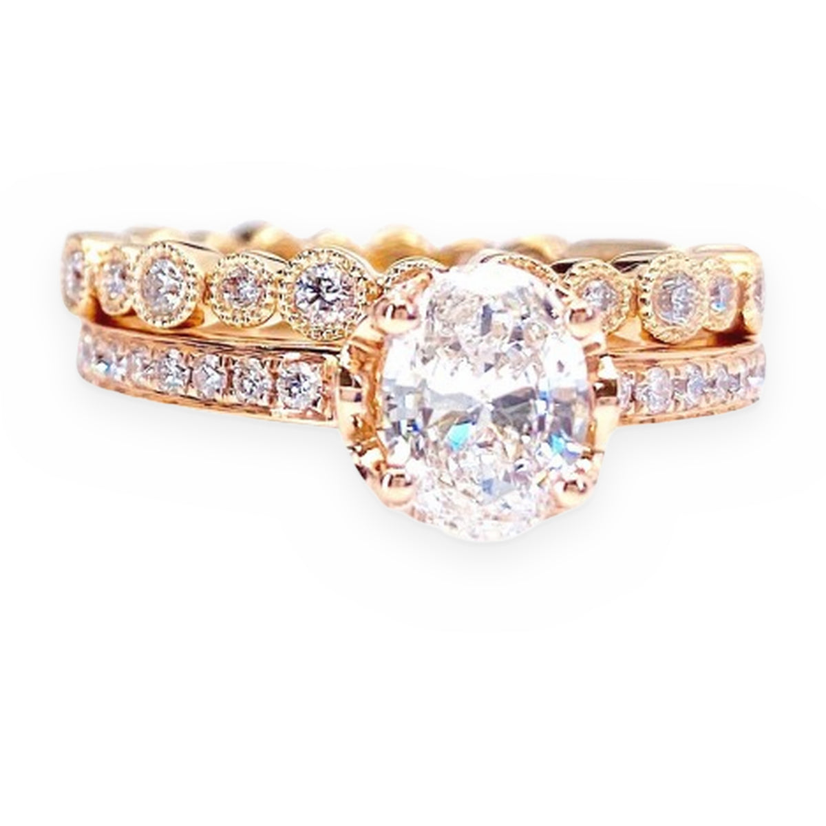 Rose gold oval diamond solitaire engagement ring with matching band, angled view