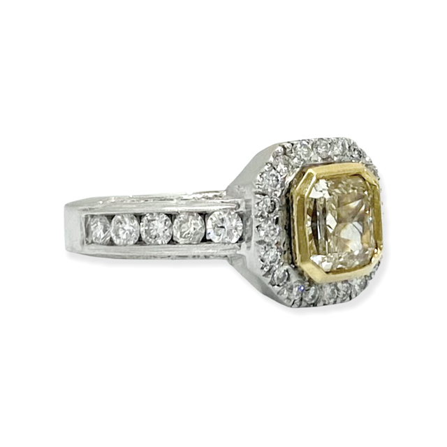 Two-tone gold radiant fancy yellow diamond bezel halo engagement ring, three-quarter angle
