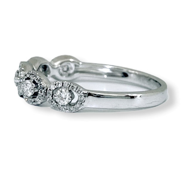 White gold oval-halo diamond band, low angled view