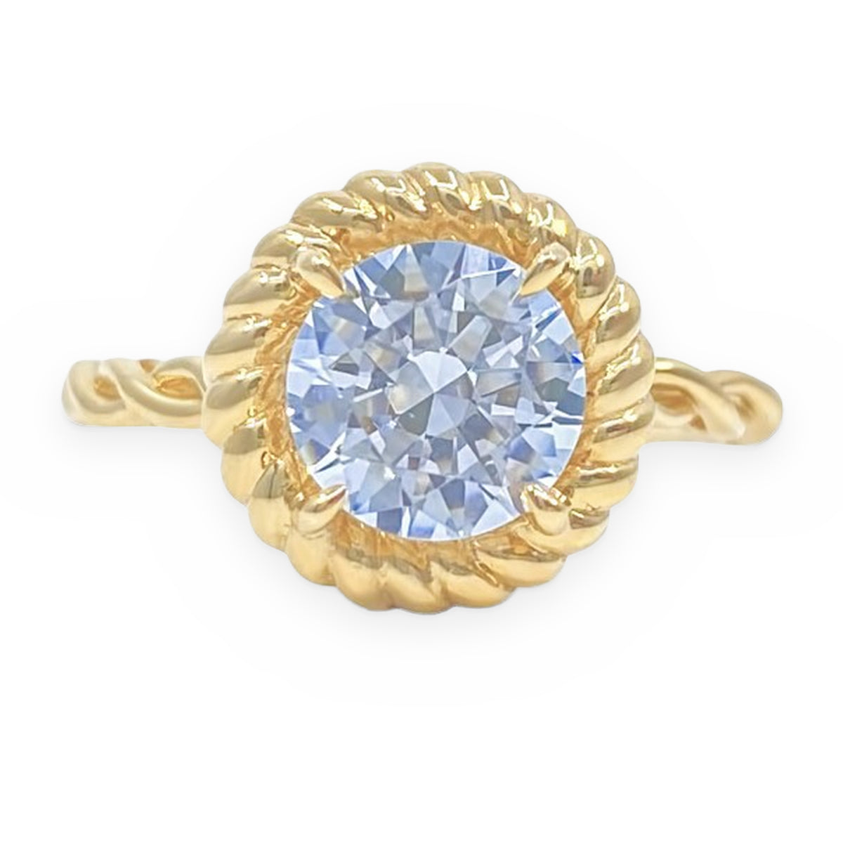 Yellow gold rope-halo solitaire ring with a round pale blue center stone
