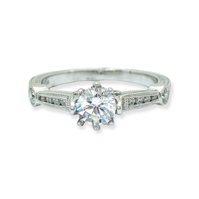 White gold solitaire engagement ring with a round center diamond and engraved band