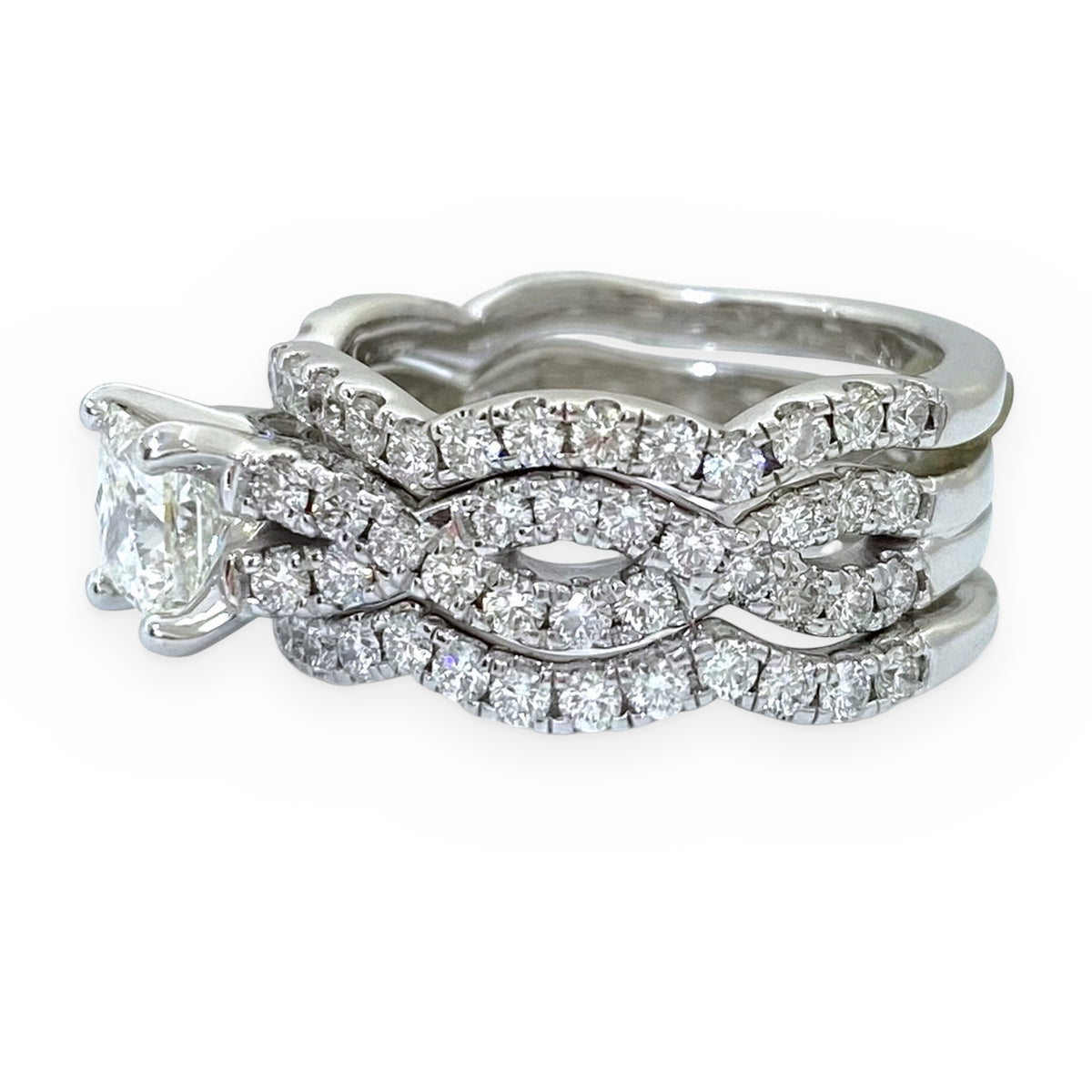 Side view of white gold princess-cut diamond engagement ring stacked with twisted diamond bands