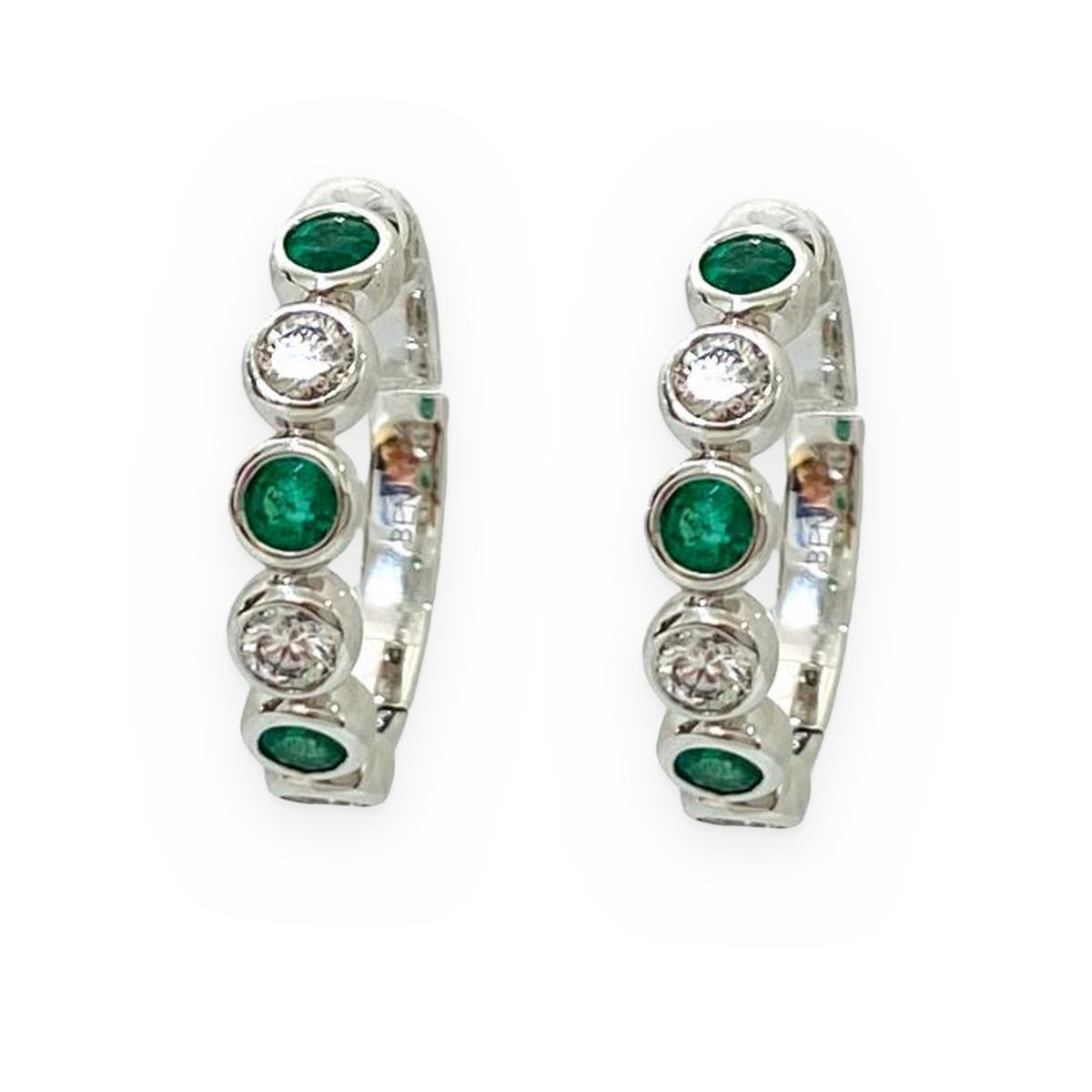 White gold huggie hoop earrings with alternating emeralds and diamonds