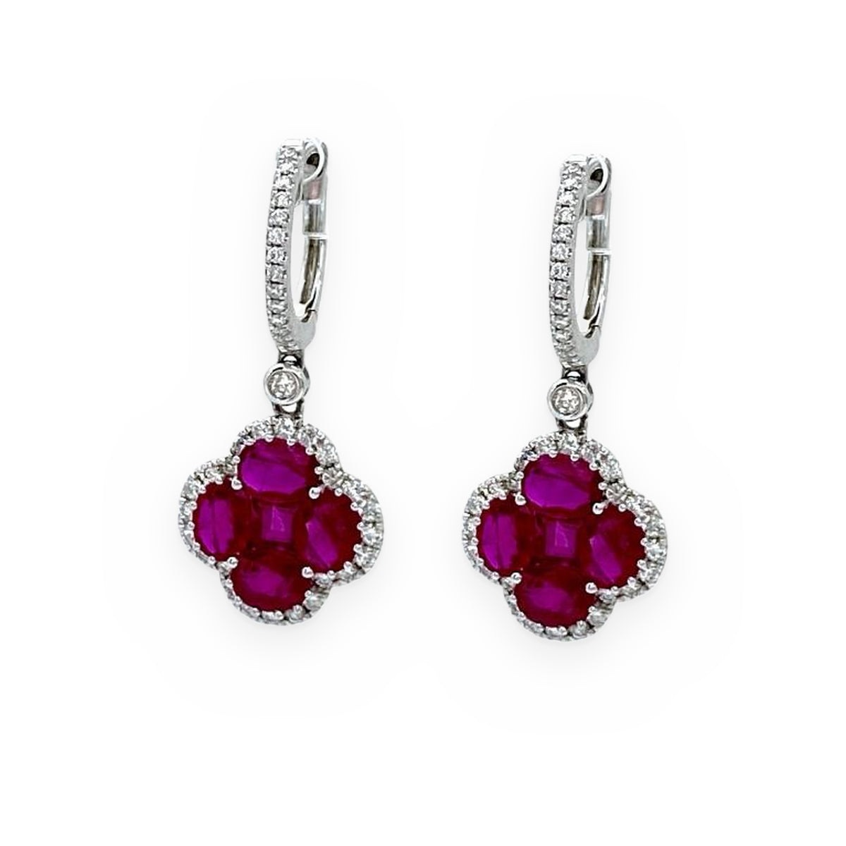 White gold ruby clover drop earrings with diamond halo, angled view