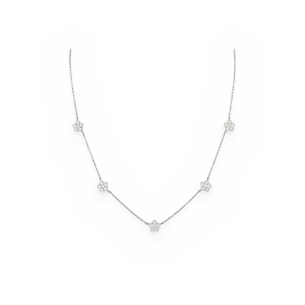 White gold necklace with five pave diamond flower stations on a gray-white ground
