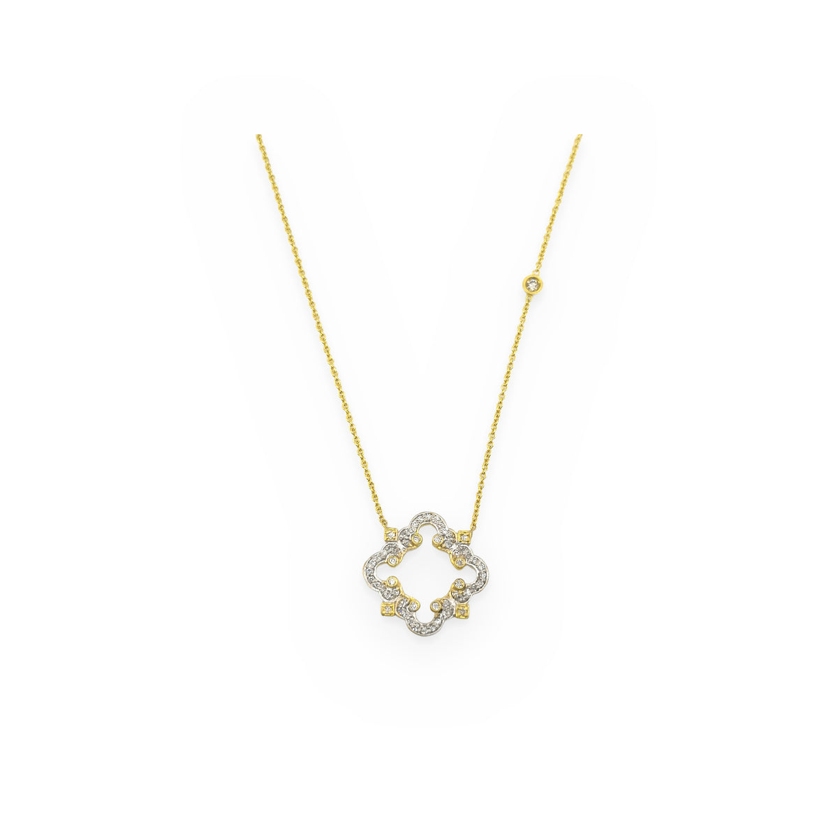 Two-tone gold openwork quatrefoil diamond pendant on a diamond station chain