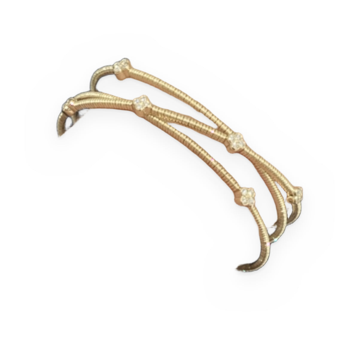 Yellow gold crossover diamond clover bangle worn on a wrist