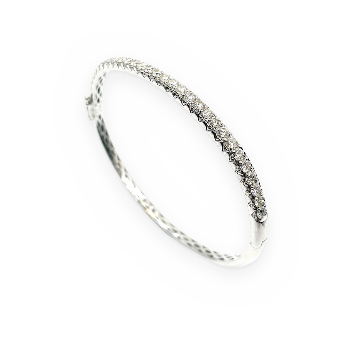 White gold diamond bangle shown at an angle with prong-set round diamonds