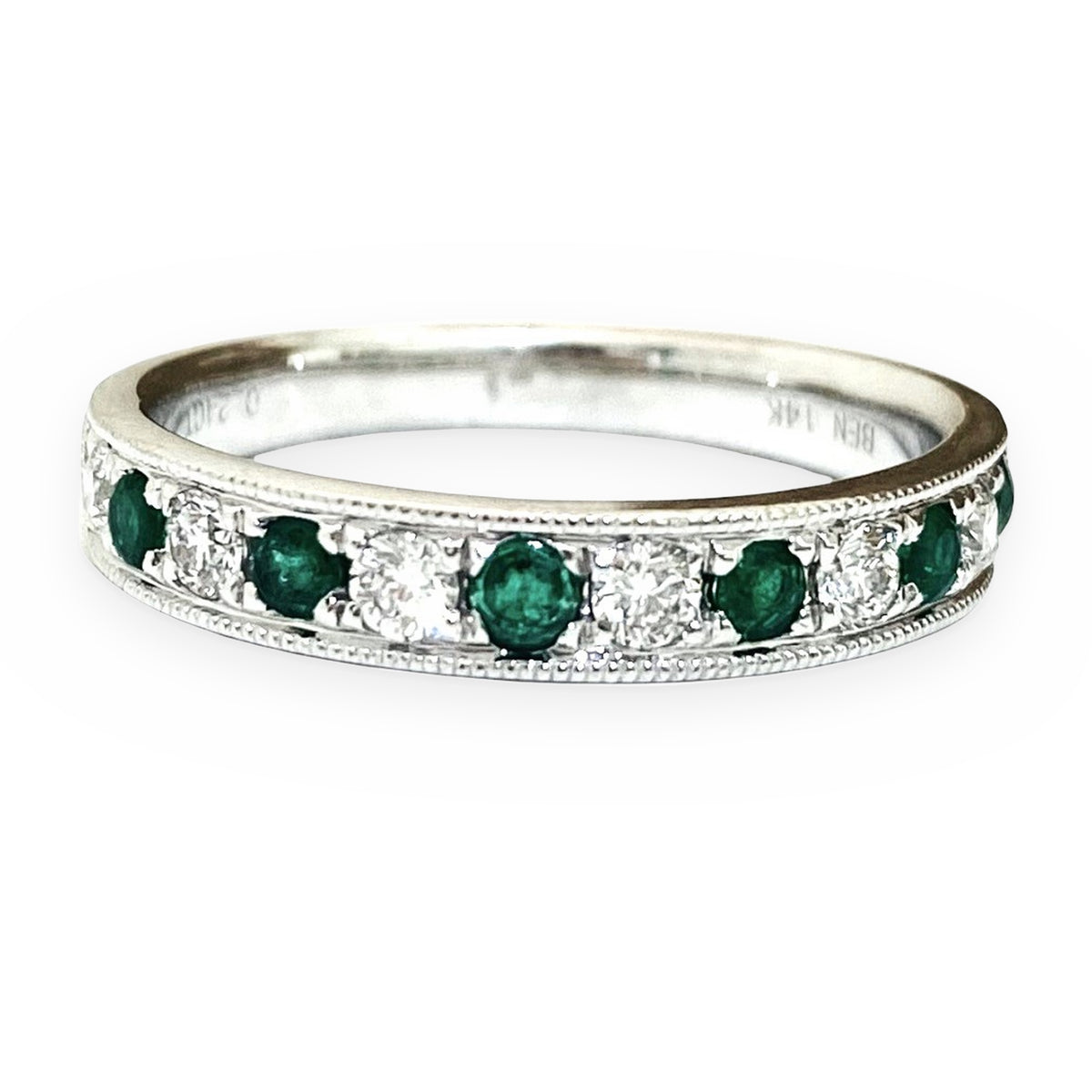 White gold band with alternating round emeralds and diamonds and milgrain edges