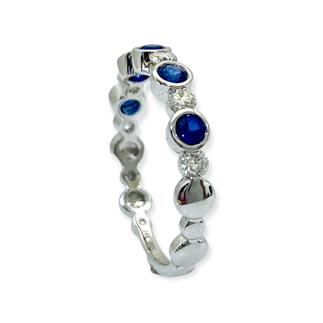 White gold bezel sapphire and diamond band shown at an angle