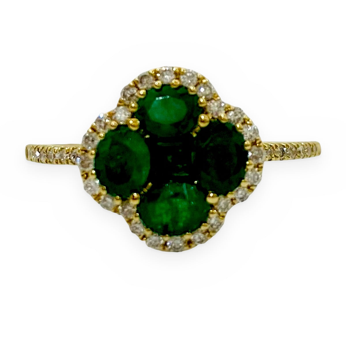 Yellow gold clover ring with four round emeralds and a diamond halo