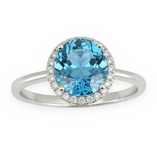 White gold ring with an oval blue topaz in a round diamond halo
