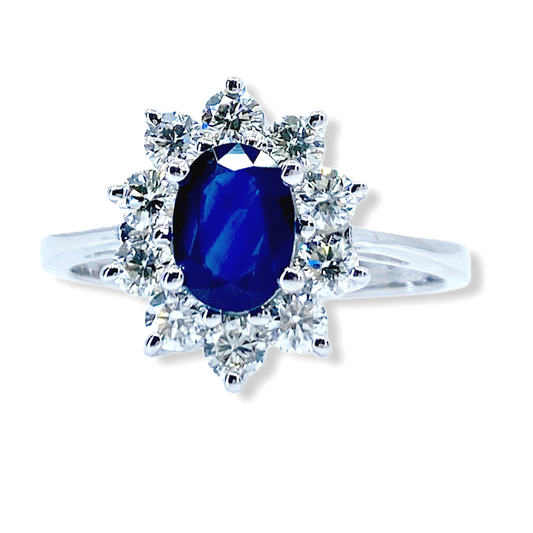 White gold ring with an oval blue sapphire in a diamond starburst halo