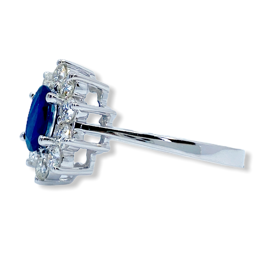 White gold oval sapphire and diamond cluster ring shown in side profile