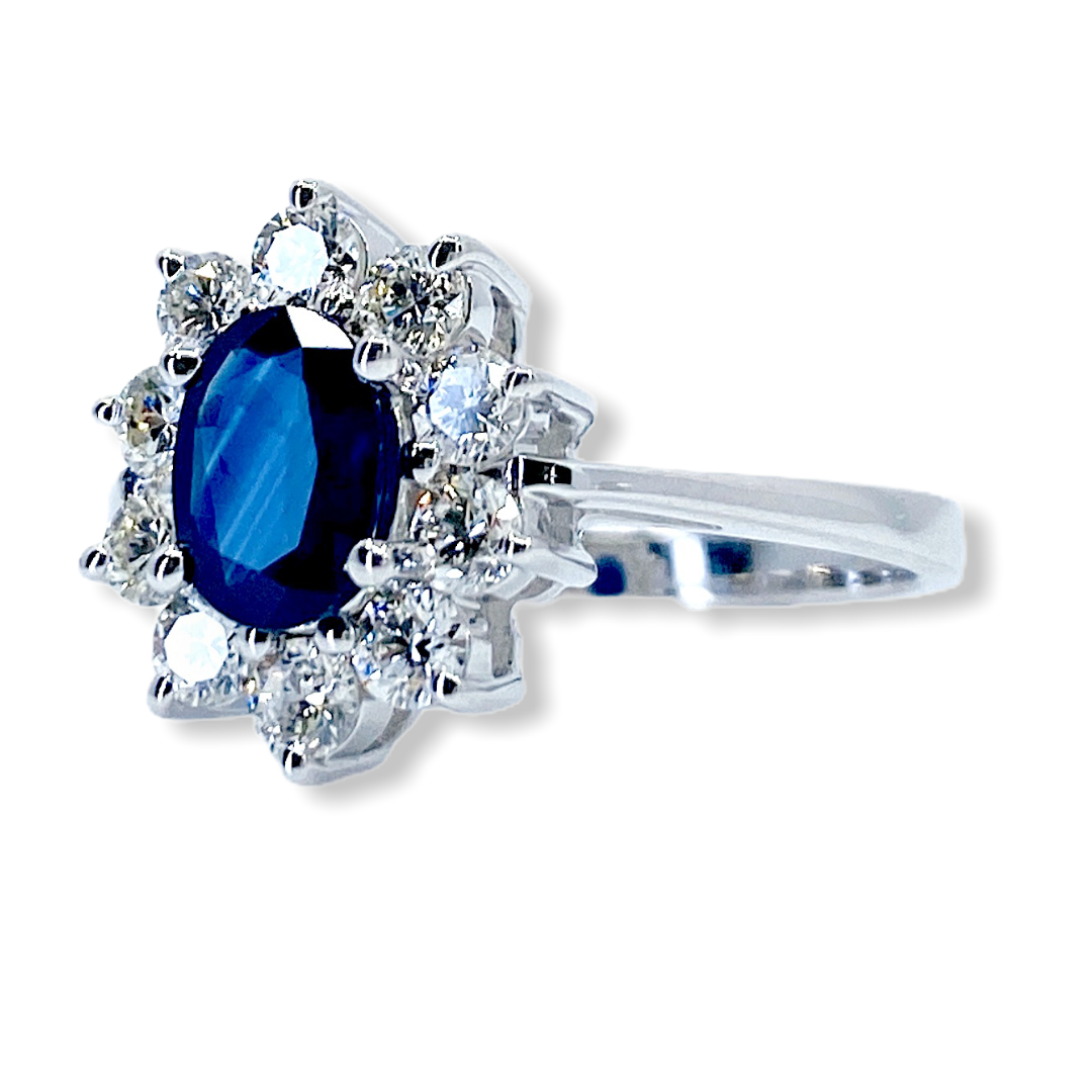 White gold oval sapphire and diamond cluster ring, angled three-quarter view