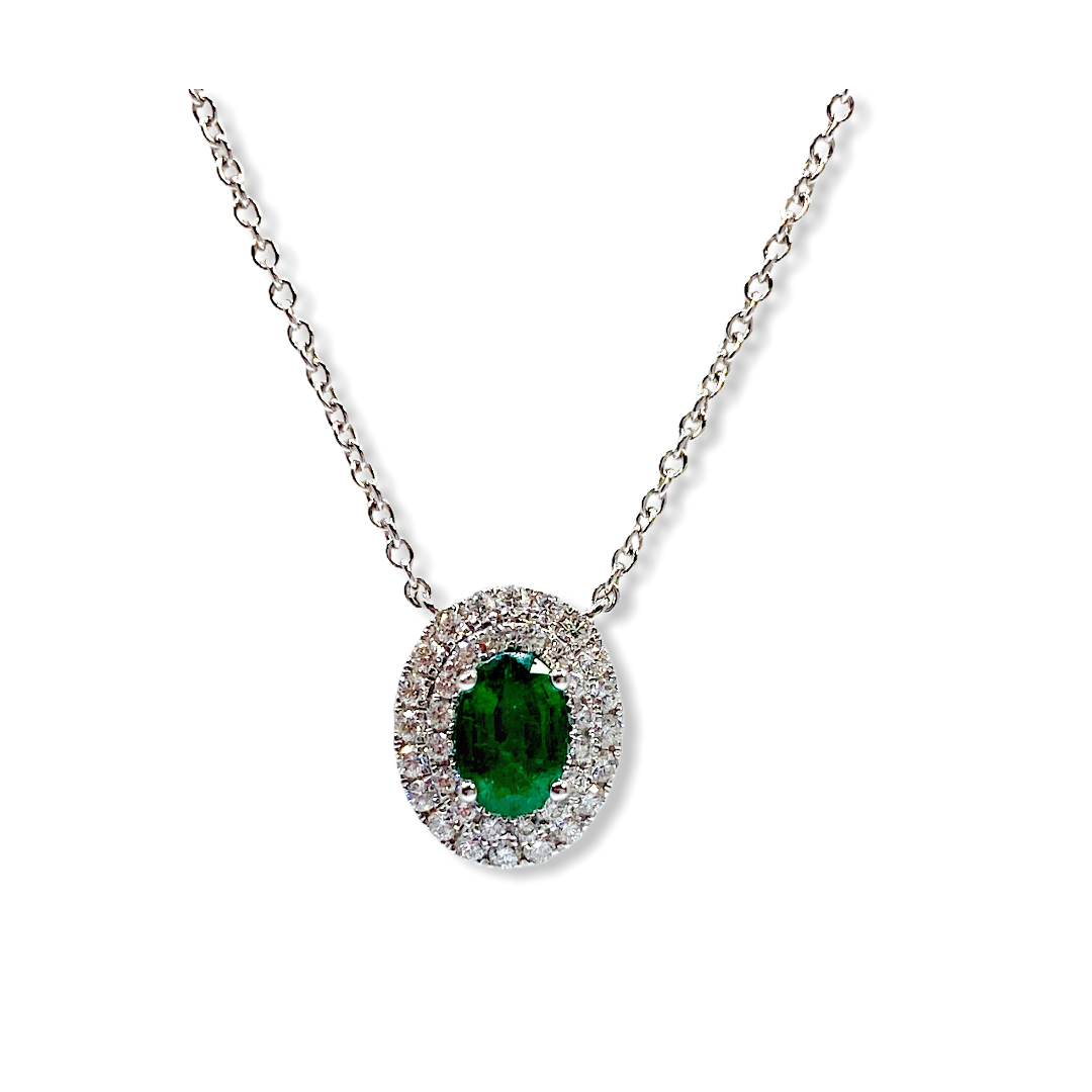 White gold oval emerald pendant with a double diamond halo on a cable chain