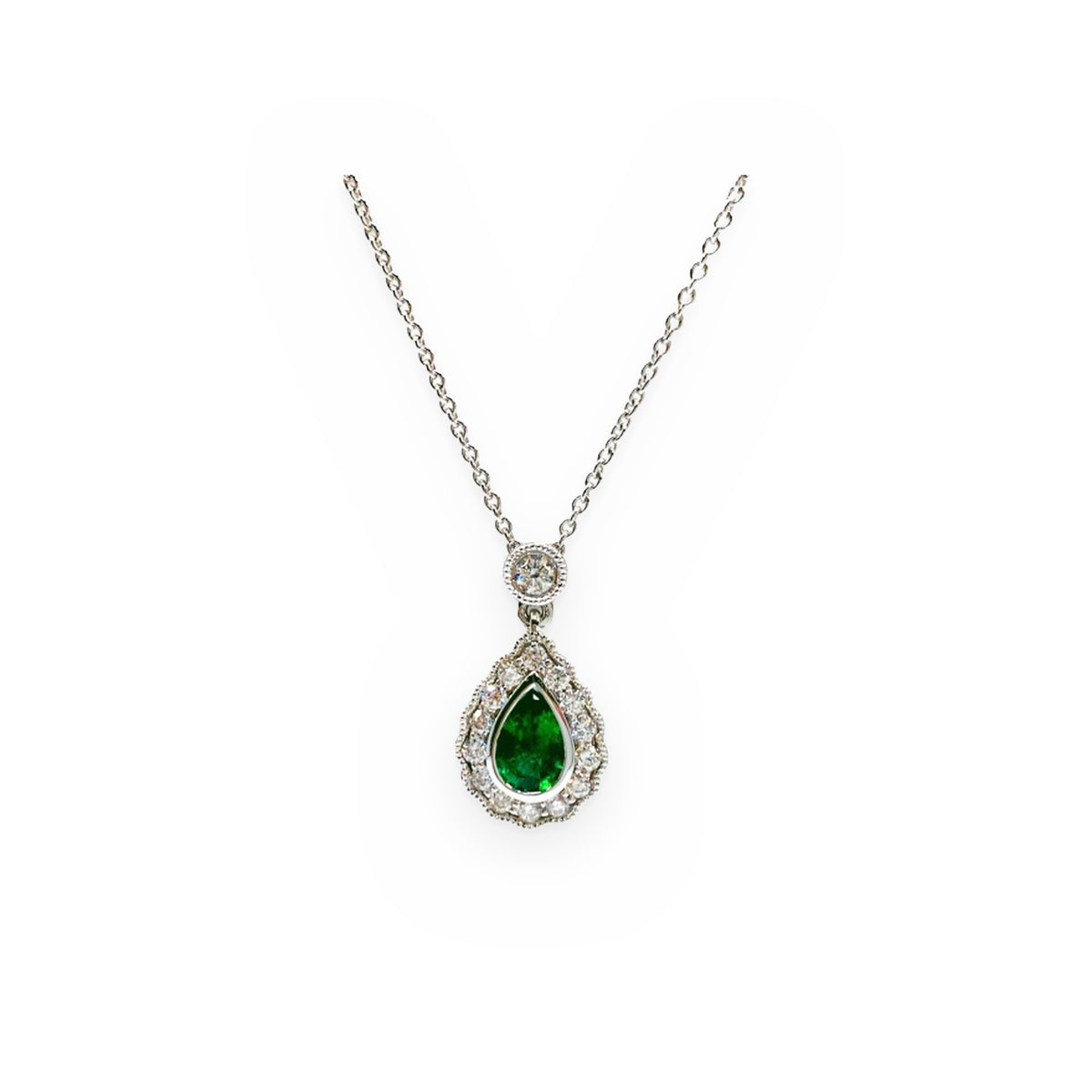 White gold pear-shaped emerald pendant with a diamond halo and bezel-set diamond bail