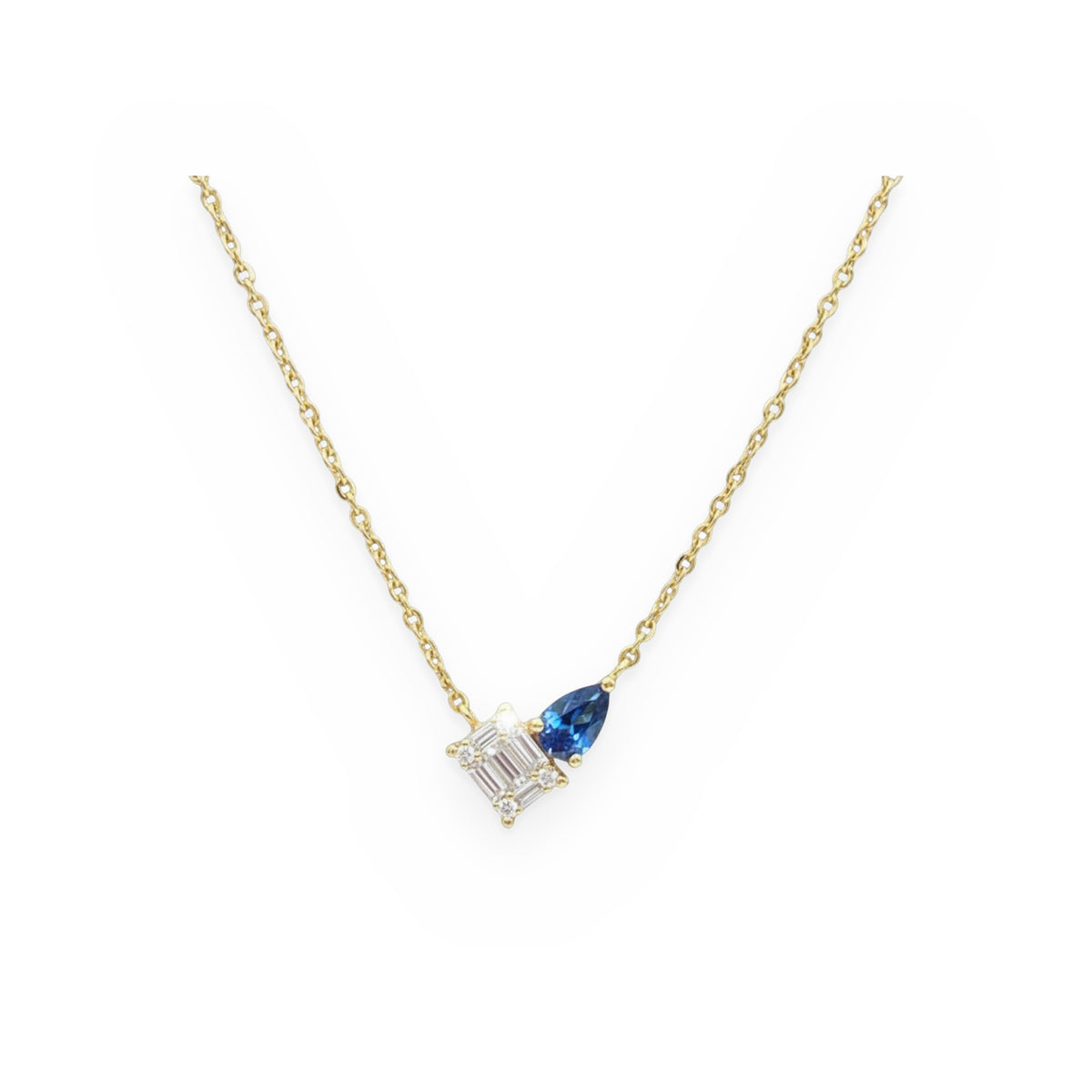 Yellow gold toi et moi necklace with a baguette diamond cluster and a blue sapphire pear