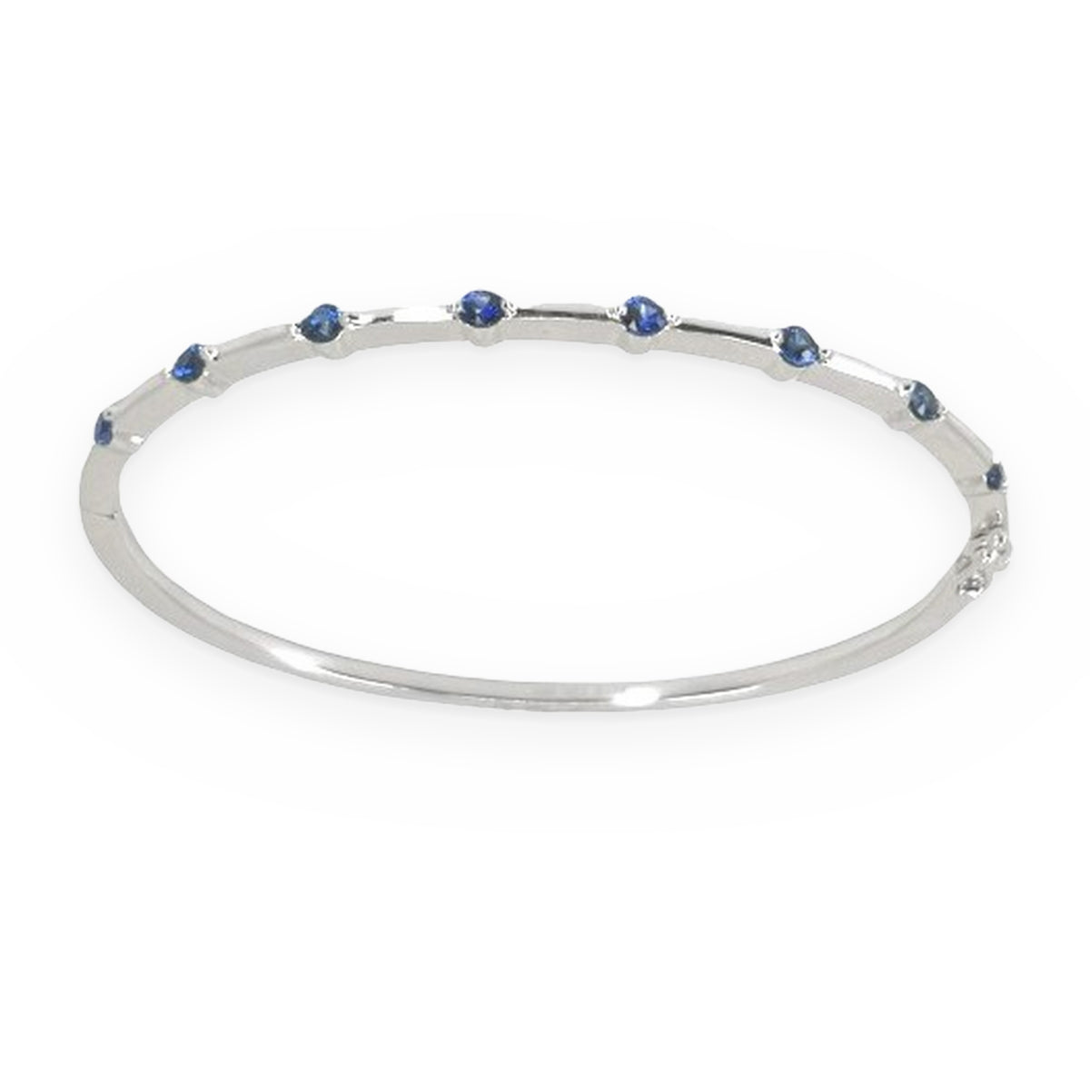 White gold thin sapphire-station bangle bracelet shown at a three-quarter angle