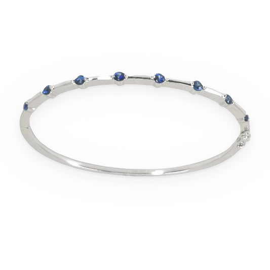 White gold thin sapphire-station bangle bracelet shown at a three-quarter angle