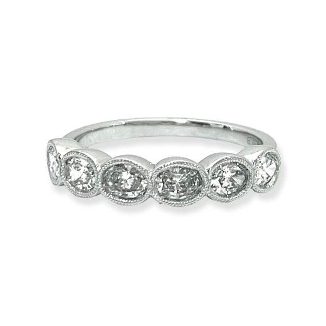 Angled view of a white gold oval diamond milgrain band