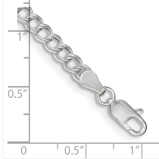 Sterling silver double-link curb charm bracelet with lobster clasp beside a ruler scale