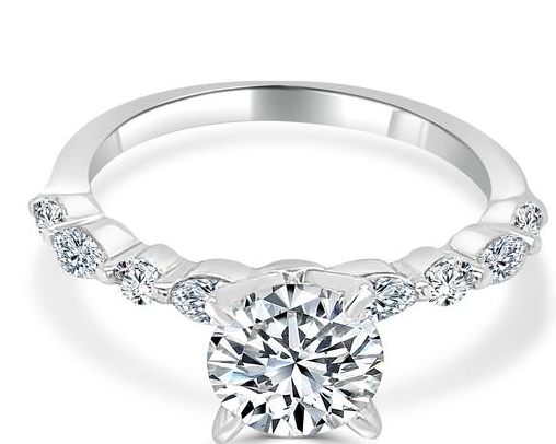 White gold round diamond engagement ring with single shared-prong accent band, angled view