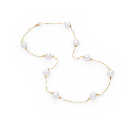 Yellow gold freshwater pearl station necklace laid in an S-curve