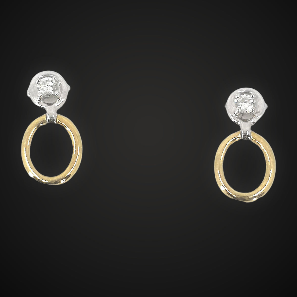 Gold and diamond drop earrings on charcoal