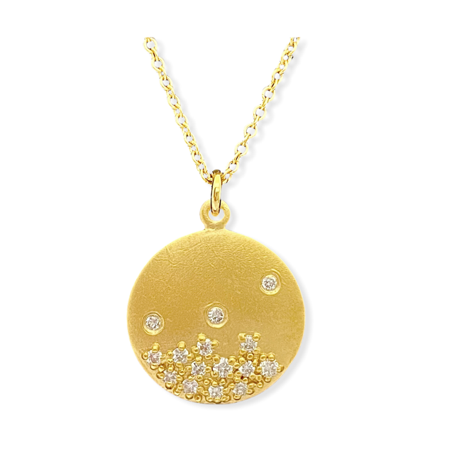 Matte yellow gold round disc pendant with scattered diamonds along the lower half